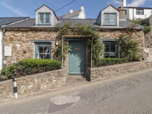 a stone house with a blue door on a street at Patty's Cottage in Haverfordwest