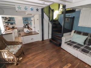 a living room with a couch and a staircase at Patty's Cottage in Haverfordwest