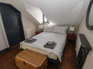 a bedroom with a bed with two towels on it at Patty's Cottage in Haverfordwest
