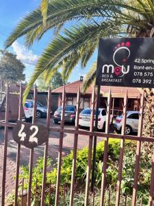 un panneau sur une clôture devant un restaurant dans l'établissement MaU Bed and Breakfast, à Krugersdorp