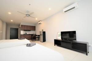 a bedroom with two beds and a flat screen tv at Comfy & Simple Apartment - 5 pax in Petaling Jaya