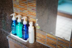 a row of bottles sitting on a counter in front of a mirror at Hotel Katsuyama Premiere in Matsuyama