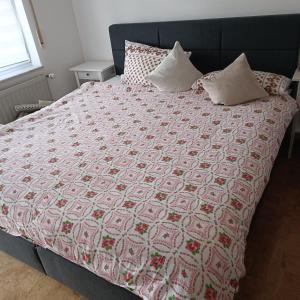 ein Bett mit einer roten und weißen Decke drauf in der Unterkunft Ferienwohnung Gogelhopf EG in Unterschneidheim