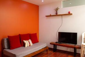 Apartamento Altoandino في اياكوتشو: غرفة معيشة مع أريكة وتلفزيون بشاشة مسطحة