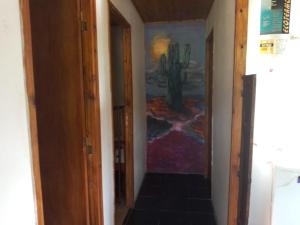 un pasillo con una pintura de un cactus en la pared en AlfaCabañas en San Marcos Sierras