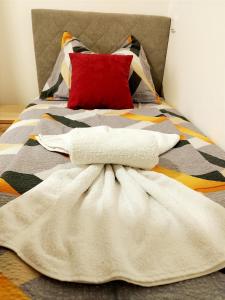 a bed with a white blanket and a red pillow at Apartman Djuras 1 in Mali Mokri Lug