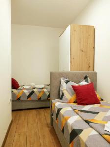 a bedroom with two beds and a chair with a bed sqor at Apartman Djuras 1 in Mali Mokri Lug