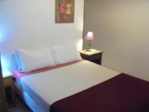 a bedroom with a bed and a lamp on a table at La Casa de Teresa in Colonia del Sacramento