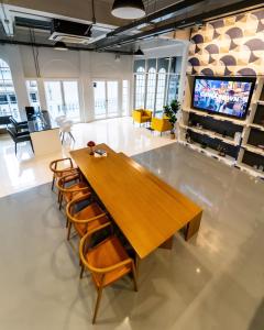 曼谷PIER 808 Hostel的大房间设有木桌和椅子