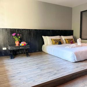 a bedroom with two beds and a table with flowers at JALMIN Hotel Samui in Koh Samui