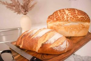 two loaves of bread on a cutting board with a knife at Churchill’s Rest in Sydney