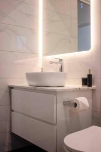Baño blanco con lavabo y aseo en Churchill’s Rest en Sídney