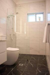 雪梨的住宿－Churchill’s Rest，一间带卫生间和玻璃淋浴间的浴室