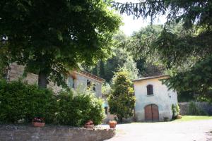 ein altes Haus und ein Gebäude mit einem Baum in der Unterkunft Villa La Ginestra - Charming Country Home in Capolona