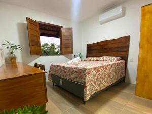 um quarto com uma cama e uma janela em Viva Guaibim: Casa de Praia com Piscina e Churrasqueira em Guaibim