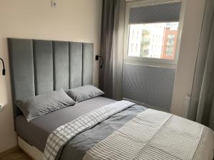 a bed in a bedroom with a window and a bedspread at Apart 89A Angielska Grobla 5 - Gdańsk Śródmieście in Gdańsk