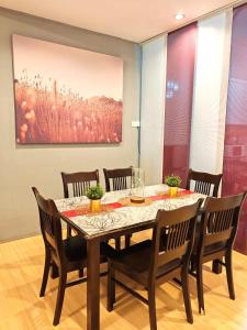 a dining room table with chairs and a painting at GWarmStay@GoldenHillsNightMarket in Brinchang