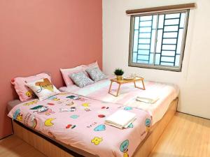 Un pequeño dormitorio con una cama con una mesa. en GWarmStay@GoldenHillsNightMarket, en Brinchang