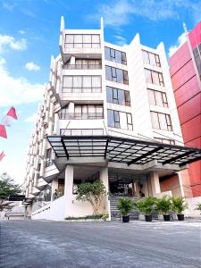 Rivoli Hotel Jakarta في جاكرتا: مبنى ابيض كبير امامه نباتات