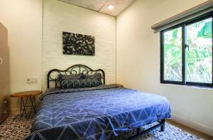Un dormitorio con una cama azul y una ventana en G House Hoian en Hoi An