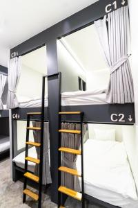 um quarto beliche com 2 beliches e uma escada em PIER 808 Hostel em Bangkok