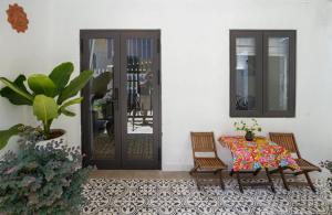 un patio con una mesa y 2 sillas y una puerta en G House Hoian en Hoi An