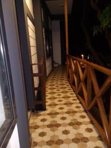 a porch with a checkered floor and a wooden fence at Panopano House in Nungwi