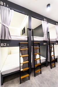 a room with three bunk beds and a staircase at PIER 808 Hostel in Bangkok