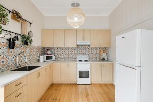 una cucina con mobili in legno e un frigorifero bianco di Cherry Tree Cottage! CBD Magic! a Toowoomba
