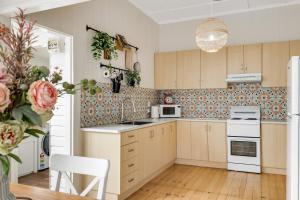 una cucina con armadi in legno e un apparecchio bianco di Cherry Tree Cottage! CBD Magic! a Toowoomba