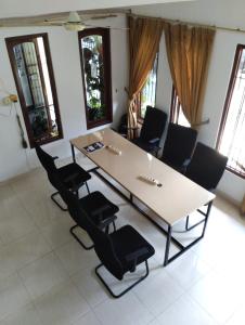 a table and chairs in a room with windows at Gorga hostel in Yogyakarta