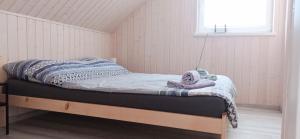 a small bed in a room with a window at Domki Poczekajka in Sasino