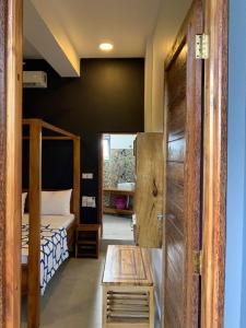 Schlafzimmer mit einem Bett, einem Tisch und einer Tür in der Unterkunft Panopano House in Nungwi