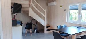 a dining room with a table and a staircase at Domki Poczekajka in Sasino