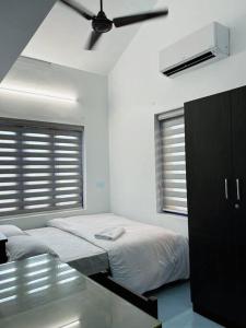 ein Schlafzimmer mit Bett und Deckenventilator in der Unterkunft Saaketh Holiday Home(2) in Kozhikode