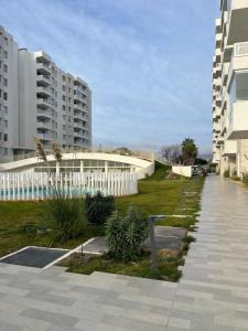 a walkway in front of a building with a white fence at Cómodo departamento a pasos de la playa in La Serena