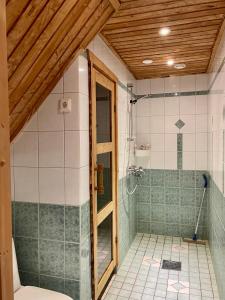 a bathroom with a shower with a glass door at Kodikas loma-asunto Tahkon ytimestä in Tahkovuori