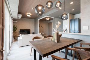 a living room with a table and a couch at JAPAVISTA Casa De Boss in Naha +79 photos