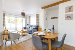 a dining room and living room with a table and chairs at The Stables in Chichester