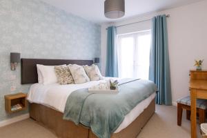 a bedroom with a large bed with blue curtains at The Stables in Chichester