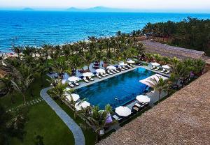 una vista aérea de un complejo con piscina y el océano en G House Hoian en Hoi An