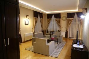 a living room with chairs and a couch and a table at Gholghola Hotel by the Buddhas of Bamyan 