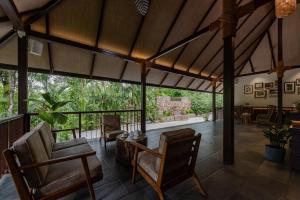 un porche acristalado con sillas y una mesa en Shanthi Kunnj Riverside Exotica Chikmagalur, en Chikmagalur 22 fotos más