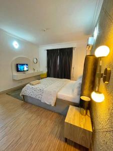een hotelkamer met een bed en een televisie bij WATER VIEW 3 BEDROOM APARTMENT WITH JACUZZI PARKING WiFi NETFLIX POOL in Lekki