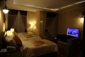 a hotel room with two beds and a flat screen tv at Gholghola Hotel by the Buddhas of Bamyan 