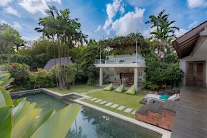 a villa with a swimming pool and a house at Villa Bumi in Kerobokan