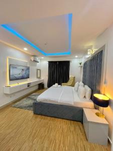 een slaapkamer met een groot bed en een tv aan de muur bij WATER VIEW 3 BEDROOM APARTMENT WITH JACUZZI PARKING WiFi NETFLIX POOL in Lekki