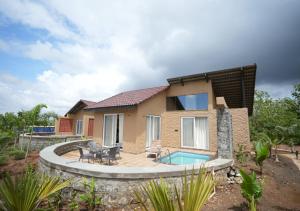 a house with a patio and a swimming pool at Waterstone resort in Linga