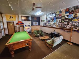 a room with a pool table and chairs and posters at Bischoff Hotel in Waratah