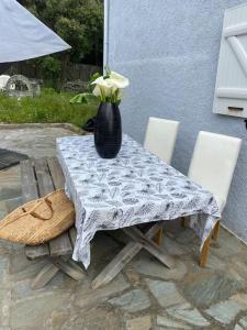 Villa Marie Cap Corse sentier douaniers في سنتوري: طاولة وكراسي عليها مزهرية